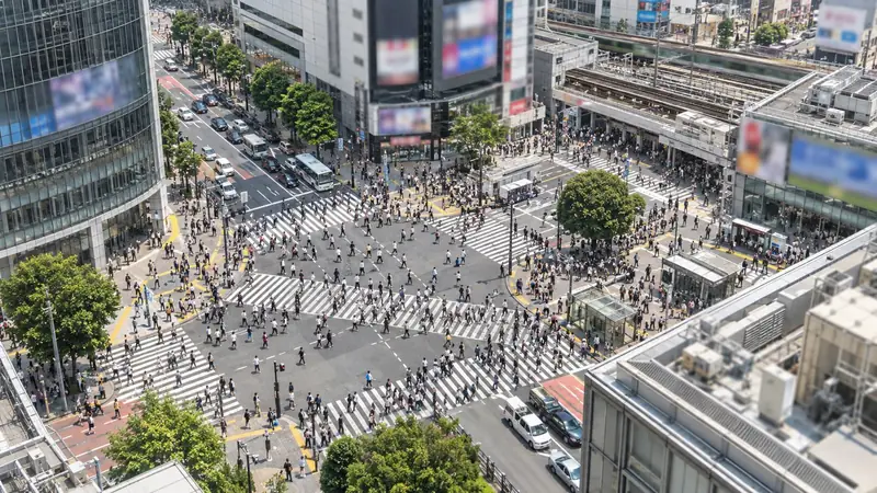 駅前の交差点の横断歩道を渡る大勢の人