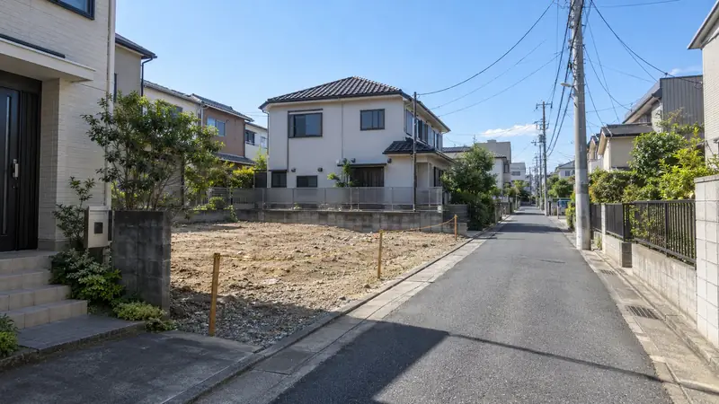 戸建て住宅が並ぶ郊外の住宅地と、その間の更地